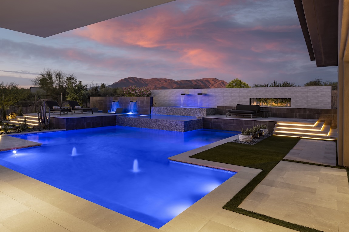 lit up pool at sunset overlooking the mountains