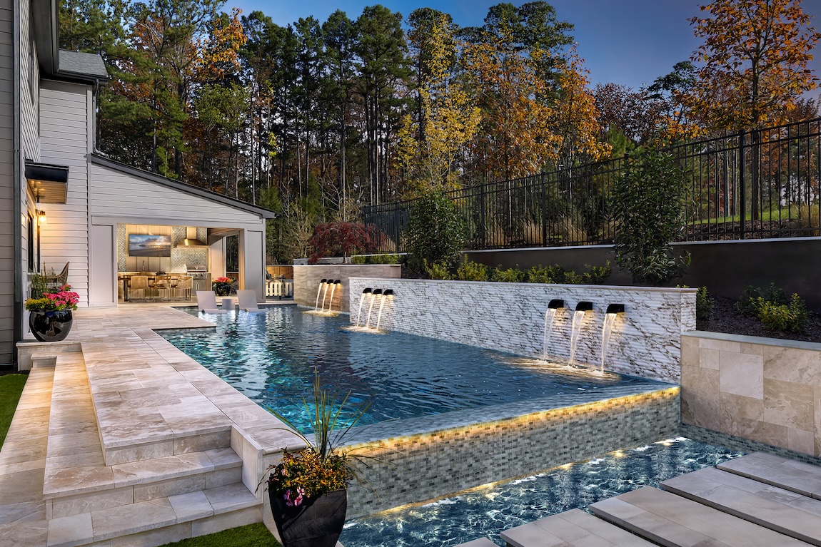 backyard pool with water features and lounge seating