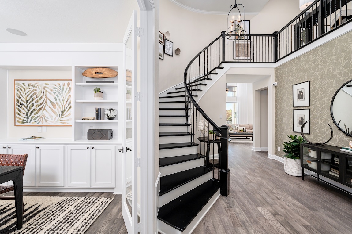 Modern foyer with curved black staircase and open-concept interior design