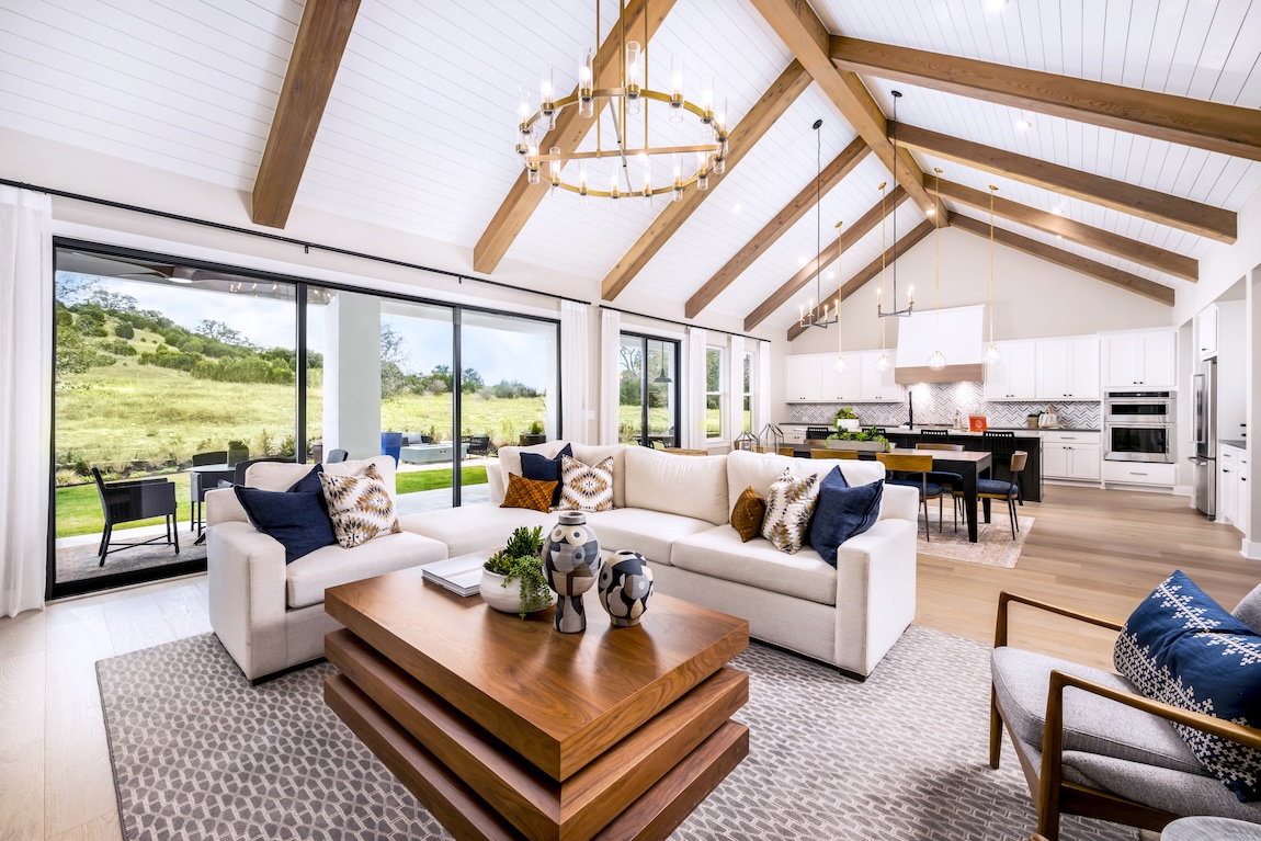 open-concept great room with wood beam ceilings
