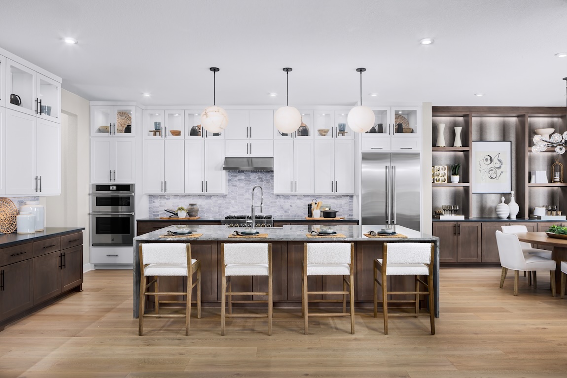 Kitchen with white cabinets, large island, and custom open shelving for elegant storage.