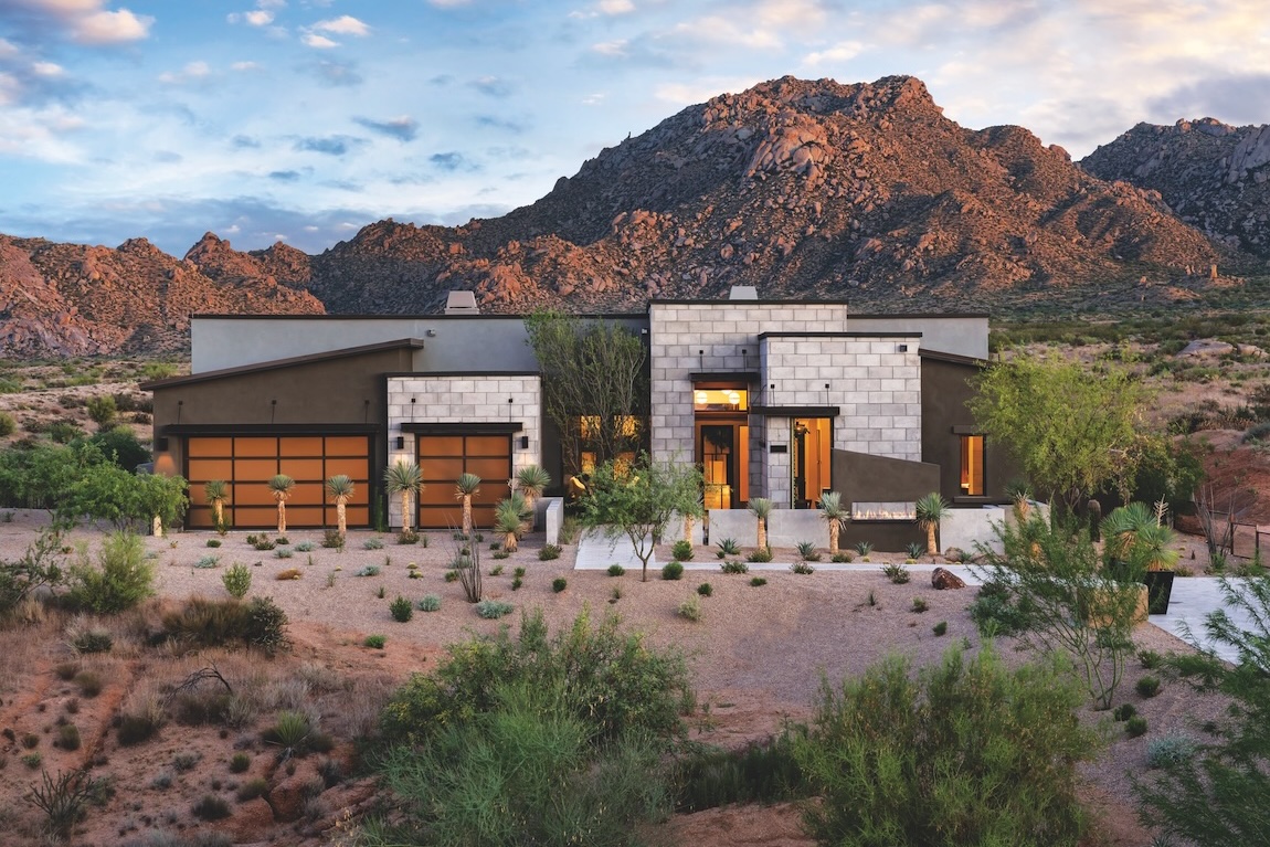 Desert contemporary exterior with clean lines, native landscaping, and scenic mountain views.