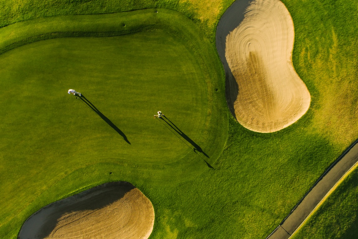 Golf course top view with players. Aerial view of golfers on putting green.