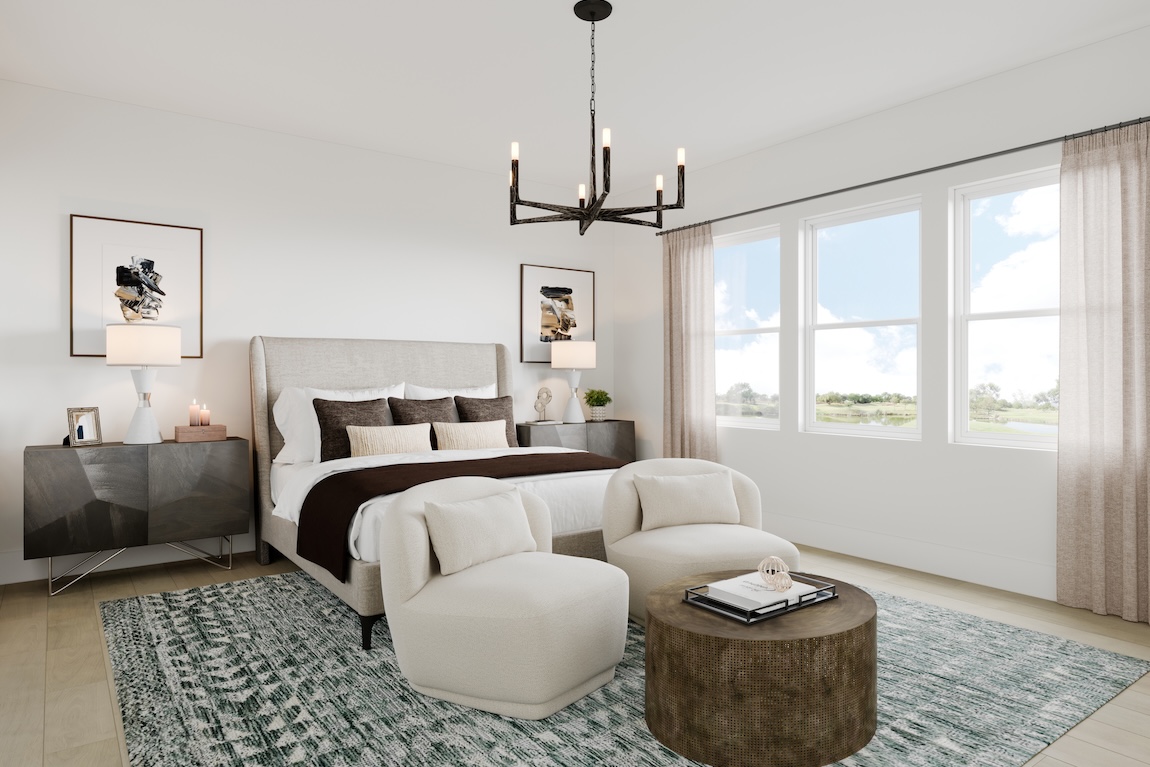 Primary bedroom suite with upholstered headboard, sculptural chandelier, cozy lounge chairs, and soft neutral decor.
