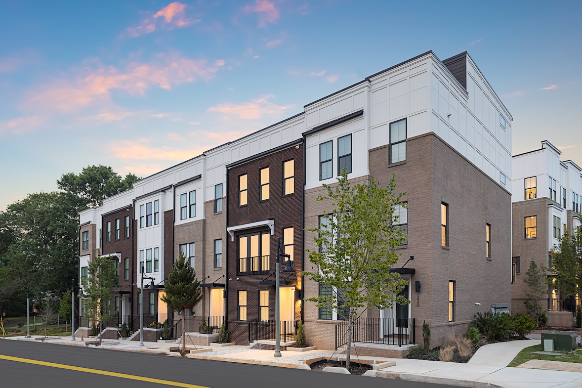 exterior of townhomes with warm interior lighting
