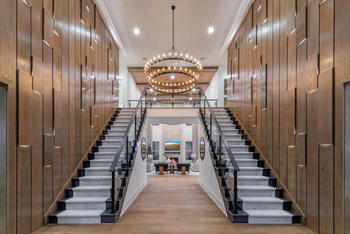 luxury dual staircase with a statement chandelier.