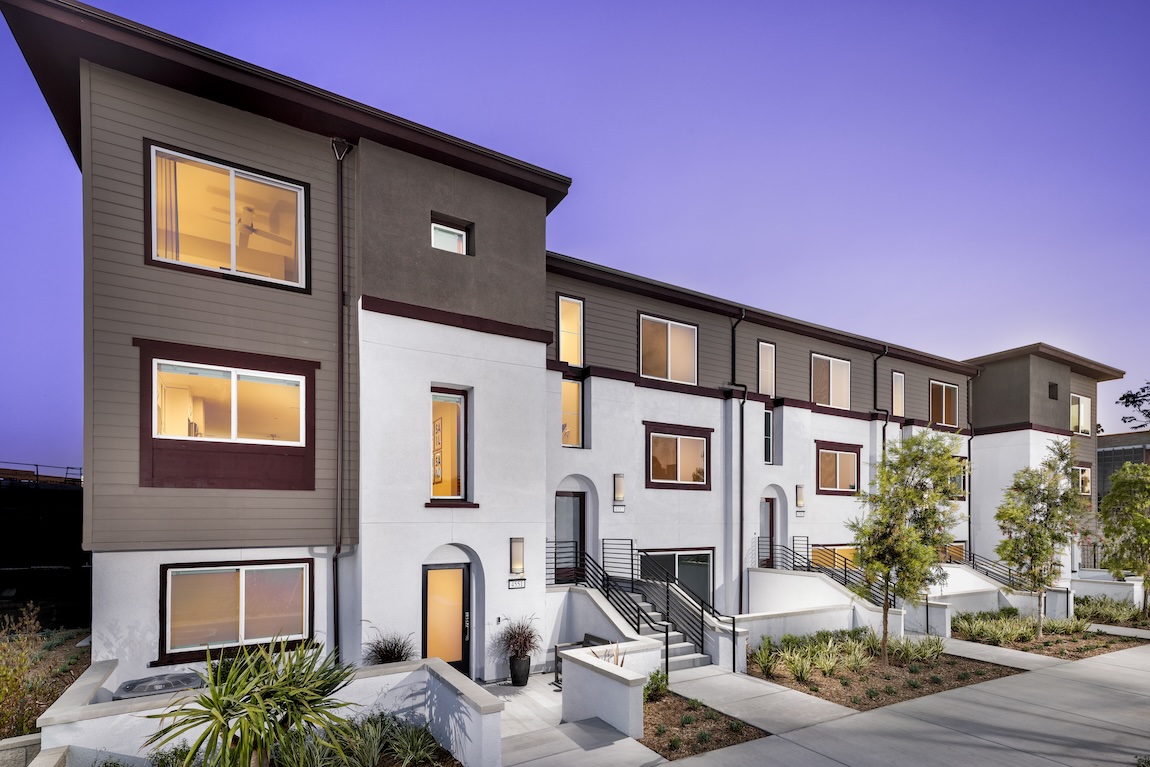 luxury exterior of townhomes with warm interior lighting.