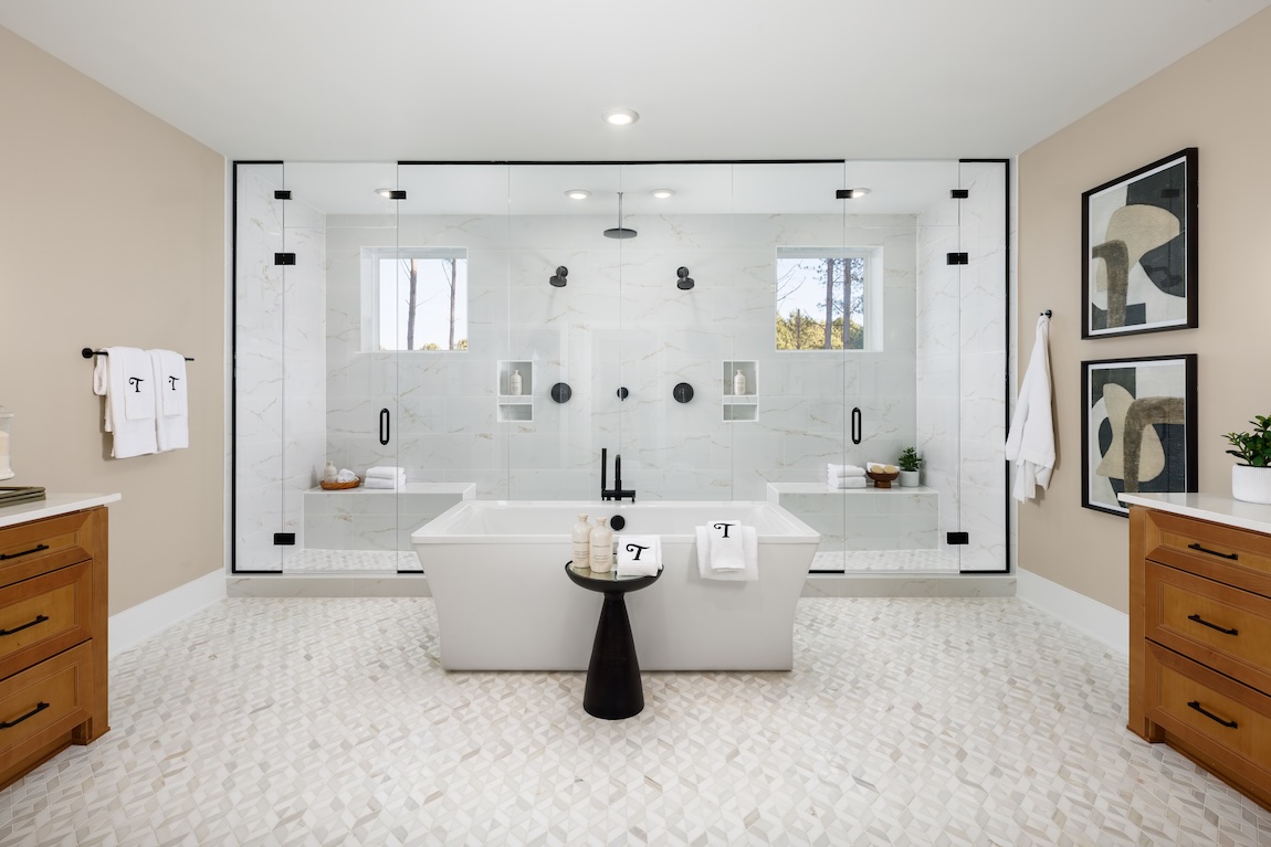 primary bathroom with neutral colors and a freestanding tub